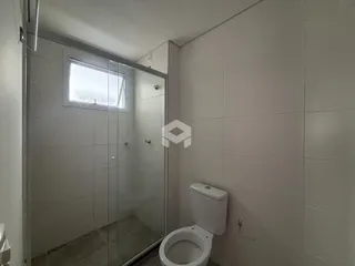 Foto de um banheiro com box de vidro e vaso sanitário.