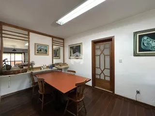 Ambiente interno com mesa de jantar de madeira e piso de madeira.