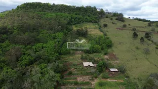 Vista aérea de uma área rural com vegetação densa e colinas no Brasil.