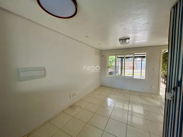 Ambiente interno com piso de cerâmica e parede branca.