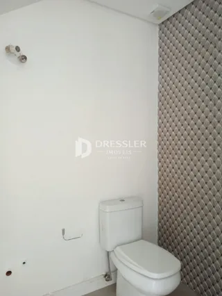 Foto de um ambiente interno mostrando uma parede branca e um vaso sanitário.