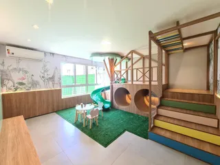 Ambiente interno de uma sala de estar com decoração rústica e paredes com mural de animais.