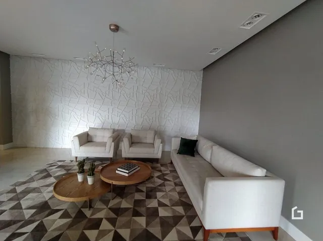 Sala de estar com sofá branco e piso de padrão geométrico.