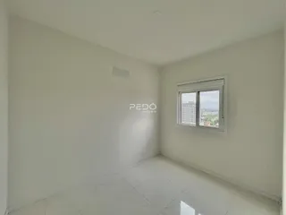 Ambiente interno de uma sala com piso de porcelanato claro.