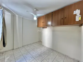 Ambiente interno de um cômodo com piso de cerâmica e armário de madeira.