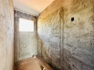Interior de um cômodo com paredes de reboco áspero.