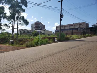 Vista externa de um edifício residencial em Lajeado, Brasil, com vegetação ao redor.