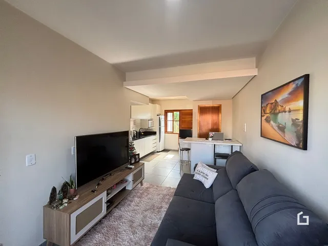 Sala de estar com sofá e televisão em um imóvel no Brasil.