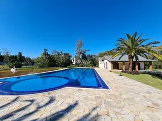 Vista externa da piscina e área de lazer com deck de pedras.