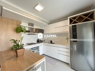 Cozinha moderna com armários brancos e bancadas claras.