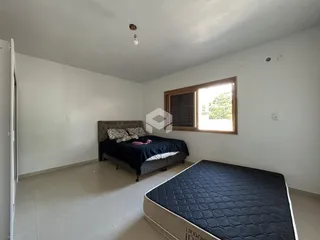 Quarto com cama e janela de madeira.