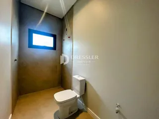 Foto de um banheiro com vaso sanitário e parede clara.