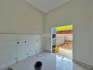 Interior de uma sala com parede em construção e porta aberta para o exterior.