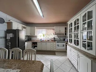 Foto de uma cozinha com armários brancos e piso de cerâmica.