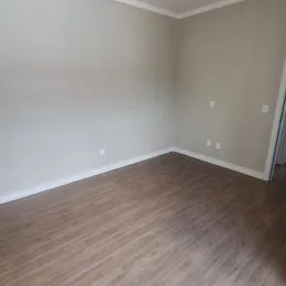 Foto de um interior com paredes brancas e piso de madeira.