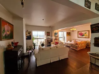 Sala de estar com sofá e piso de madeira em uma residência.