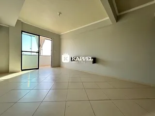 Uma sala ampla com piso de cerâmica e porta de vidro voltada para o exterior.