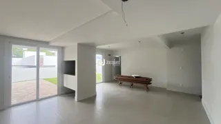 Ambiente interno amplo com piso claro e portas de vidro que dão acesso ao exterior.