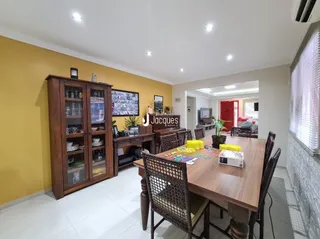 Sala de estar com móveis de madeira e paredes amarelas.