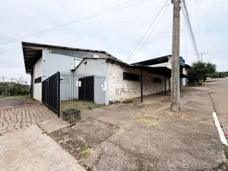 Fachada de um prédio comercial em Lajeado, Brasil, com cerca e poste de luz.