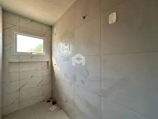 Interior de um banheiro com revestimento de azulejos brancos.