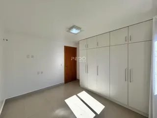 Hall de entrada com paredes brancas e armários brancos.