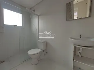 Foto de um banheiro com revestimento branco e box de vidro.