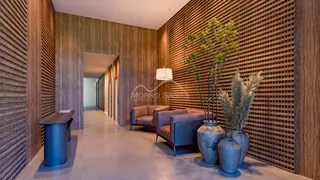 Sala de estar com sofá e poltronas em um ambiente com painéis de madeira.