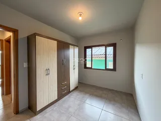 Quarto com armário embutido e janela de madeira.