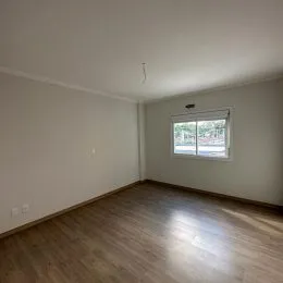 Foto interna de um ambiente com piso de madeira clara.