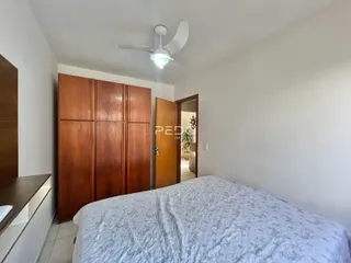 Quarto com armários de madeira e cama em um ambiente claro.
