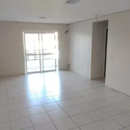 Sala de estar com piso de cerâmica e grande janela iluminada.