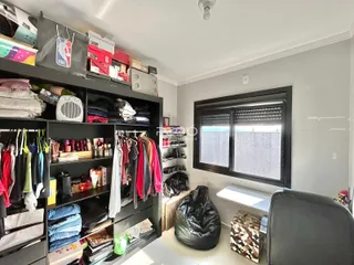 Foto de um ambiente interno com estantes pretas cheias de roupas.