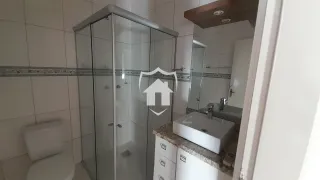 Foto de um banheiro com box de vidro e louças sanitárias.