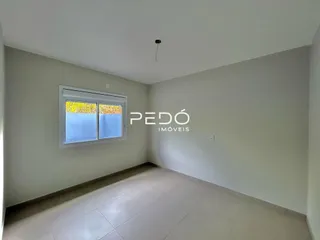 Vista interna de uma sala com paredes brancas e piso claro.