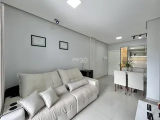 Sala de estar moderna com sofá e paredes cinzas em um imóvel no Brasil.