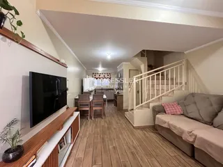 Ambiente interno com piso de madeira e escadaria em uma sala de estar.