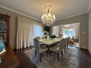 Uma sala de jantar com mesa e cadeiras em um ambiente claro.