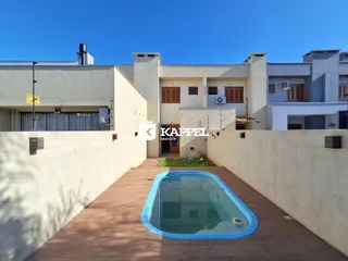 Vista externa de uma propriedade mostrando uma piscina e um deck de madeira.
