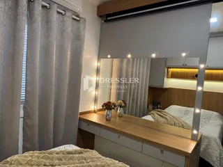Quarto com cama e cortinas em ambiente interno.