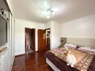 Quarto com piso de madeira e cama no interior de uma residência.
