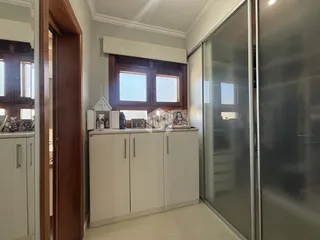 Hall com portas de madeira e armários brancos em um imóvel no Brasil.