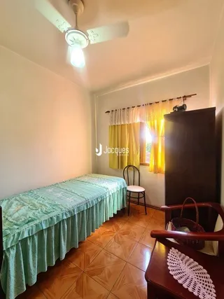 Foto de um quarto com cama e piso de madeira.