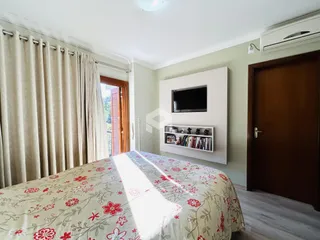 Quarto com cama e janela com cortinas em um imóvel em Lajeado.