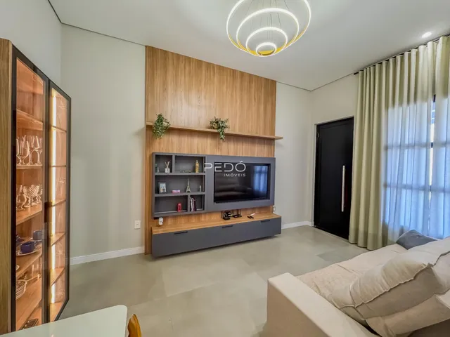 Sala de estar com painel de madeira e televisão em um imóvel em Lajeado, Brasil.