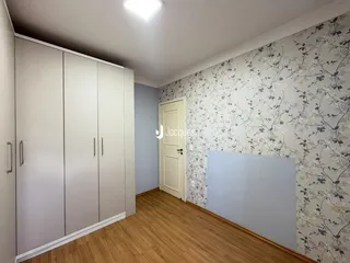 Quarto com armários embutidos e piso de madeira.