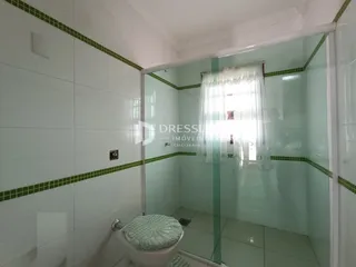 Foto de um banheiro com revestimento de azulejos brancos e verdes.