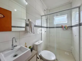 Banheiro com piso cerâmico e box de vidro em um imóvel no Brasil.