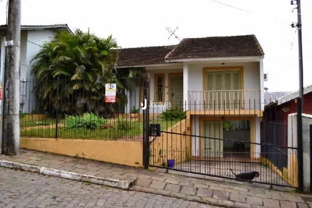 Fachada de uma residência em Lajeado, Brasil, com cerca e vegetação.
