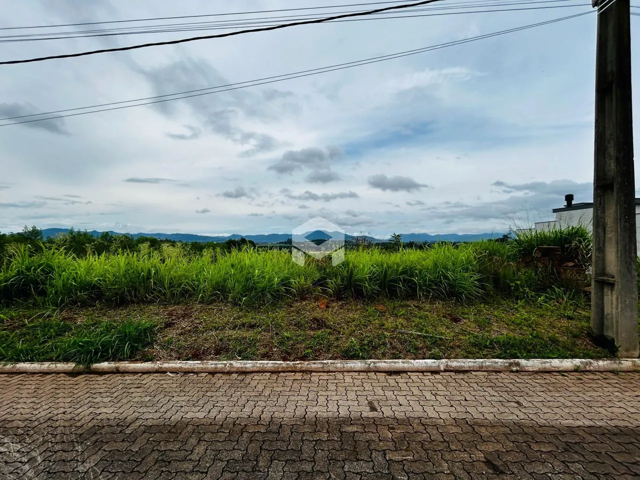 Vista da propriedade com vegetação e paisagem ao fundo.